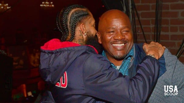 Big U smiling and embracing a friend in a warm moment before reports of his son’s death shocked the hip-hop community